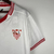 Camisa torcedor masculina branca do Sevilla FC 2023/2024 com detalhes em vermelho.