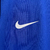 Camisa masculina azul do time de futebol da França, temporada 2024/2025, marca Nike, com logo e detalhes em vermelho e amarelo.