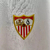 Camisa branca do Sevilla FC, modelo torcedor masculina da temporada 2024/25, com detalhes em vermelho e logotipo da Castore.