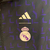 Agasalho corta vento Real Madrid duplo face 2023/24 da Adidas, nas cores azul e preta, com detalhes em amarelo.