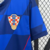 Camisa masculina Nike da seleção da Croácia, modelo II 2024/25, em azul com detalhes em vermelho e estampa quadriculada.