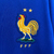 Camisa masculina azul do time de futebol da França, temporada 2024/2025, marca Nike, com logo e detalhes em vermelho e amarelo.