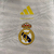 Agasalho corta vento da Real Madrid, modelo 2024/25, com estampa colorida e logotipo do clube, ideal para torcedores.