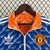 Agasalho corta vento Adidas do Manchester United, modelo duplo face, nas cores azul e laranja, com estampa geométrica e logo do clube.