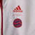 Agasalho corta vento vermelho e branco do Bayern de Munique, modelo dupla face 2023/24 da Adidas, com logotipo do clube e listras nas mangas.