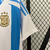 Camisa de futebol masculina da seleção argentina, modelo 2024/25, nas cores azul e branca, com detalhes em dourado.