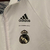 Agasalho corta vento da Real Madrid, modelo 2023/24 da Adidas, com estampa de dragões em fundo branco.