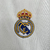 Camisa branca do Real Madrid I 2023/2024 para torcedores masculinos da Adidas, com detalhes em dourado e logo da equipe.