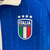 Agasalho Corta Vento Itália Dupla Face 2023/24 da Adidas, na cor azul e branca, exibindo o logo da seleção italiana e detalhes em verde nas mangas.

