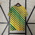 Camisa torcedor masculina da seleção da Jamaica, modelo 2024/2025, nas cores amarela, preta e verde, com listras em diferentes direções.