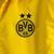 Agasalho corta vento amarelo do Borussia Dortmund, modelo dupla face da Puma, com logotipo e design moderno.