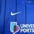 Camisa azul do Portsmouth I 2024/25, modelo torcedor masculino da Nike, com listras verticais e logotipo da Universidade de Portsmouth.