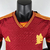 Camisa masculina vermelha da Roma I 2023/2024, da Adidas, com detalhes em amarelo e logotipo do time.