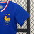 Uniforme infantil da seleção francesa, composto por camiseta azul e shorts brancos, com detalhes em vermelho e o logo da Nike.