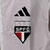 Agasalho corta vento vermelho e branco da Adidas, modelo São Paulo, com logo do clube e listras nas mangas.