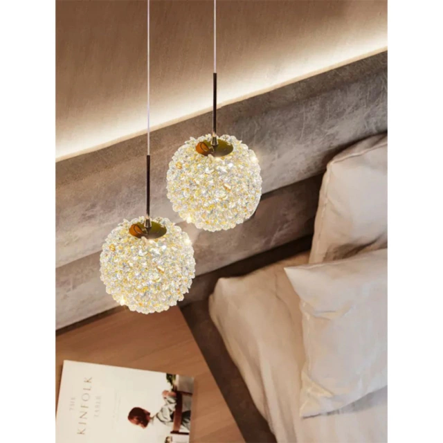 Iluminação pendente com esferas de cristal, criando um ambiente aconchegante ao lado da cama.