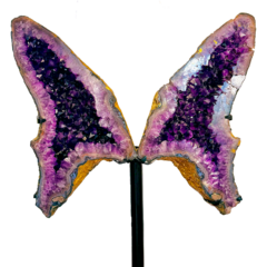 Escultura de borboleta feita de cristal roxo, com detalhes em amarelo e azul, destacando-se em um suporte.