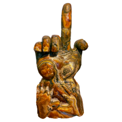 A decorative sculpture of a hand with an index finger raised, featuring intricate patterns and earthy tones.