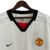 Camisa retrô branca do Manchester United II 2002/2003, fabricada pela Nike, com detalhes em preto e logotipo da Vodafone.

