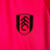 Camisa rosa do Fulham Away 23/24, confeccionada pela Adidas, com detalhes em preto e logotipo do time.

