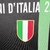 Camisa preta do Napoli, edição Champions 23/24, com detalhes em verde, vermelho e branco, destacando o logo EA7 e a inscrição "Campioni d'Italia 22/23".

