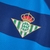 Camisa do Real Betis II 22/23 na cor azul com detalhes em branco, confeccionada pela Hummel, exibindo o logo do time e da marca.

