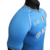 Camisa masculina azul do Napoli, modelo EA7 da temporada 23/24, com detalhes em verde, branco e vermelho e logotipo da equipe.

