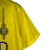 Camisa amarela do Al-Nassr, modelo 23/24, fabricada pela Nike, com detalhes em azul e logo do time.

