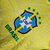 Camisa amarela da Seleção Brasileira, modelo 23/24, com detalhes em verde e azul, estampada com o escudo da CBF.

