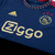 Camisa Ajax Away 22/23 da Adidas, na cor azul, com detalhes em vermelho e logotipo da Ziggo.

