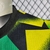 Camisa pré-jogo do Arsenal, modelo 22/23, nas cores amarelo, preto e verde, com logo da Adidas e patrocinador Emirates.

