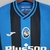 Camisa masculina do Atalanta, azul e preto, com logo da equipe e patrocinador Plus500.

