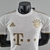 Camisa branca do Bayern de Munique, modelo away 22/23, com detalhes em dourado e logo da Adidas.

