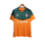 Camisa de treino laranja do Fluminense, modelo masculino da Umbro, com detalhes verdes e logo do patrocinador Betano.