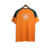 Camisa de treino laranja do Fluminense, modelo masculino da Umbro, com detalhes verdes e logo do patrocinador Betano.