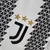 Camisa feminina branca e preta da Juventus I 22/23, com detalhes em triângulos e logo da Adidas.

