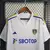 Camisa branca do Leeds United, modelo 23/24, com detalhes em azul e logo da Adidas.

