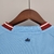 Camisa azul do Manchester City, modelo 22/23, com detalhes em vermelho e logo da Puma.

