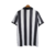 Camisa de torcedor masculina do Newcastle, com listras verticais em preto e branco e logo do time na parte frontal.

