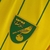 Camisa amarela do Norwich City, temporada 22/23, com detalhes em verde e logotipo da equipe.

