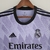 Camisa roxa do Real Madrid, modelo away, da coleção 22/23, fabricada pela Adidas, com detalhes em preto e logotipo do clube.

