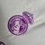 Camisa branca do goleiro do Real Madrid 23/24 com detalhes em roxo e logo da Adidas.

