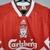 Camisa retrô do Liverpool, modelo home de 1993, nas cores vermelho e branco, com detalhes em verde e logo da Carlsberg.