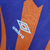 Camisa retrô branca da seleção da Escócia, com detalhes em laranja e roxo, fabricada pela Umbro.

