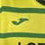 Camisa amarela do Norwich City FC com detalhes em verde, modelo para torcedores, da marca Joma, temporada 23/24.

