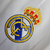 Camisa retrô do Real Madrid I 12/13, branca com detalhes em azul e patches da UEFA Champions League.

