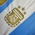 Camisa da Seleção da Argentina I 24/25, manga longa, com listras azuis e brancas e detalhes em dourado.

