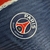 Camisa azul do Paris Saint-Germain, modelo 24/25, com detalhes em vermelho e logo da Nike.

