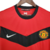 Camisa retrô do Manchester United da temporada 2009/2010, na cor vermelha, com detalhes em preto e logo da Nike.

