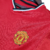 Camisa retrô do Manchester United da temporada 2000/2001, na cor vermelha, com detalhes em preto e logo da Umbro.

